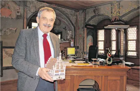  ?? FOTO: WOLFGANG HEYER ?? Das Rathaus hält der scheidende Bürgermeis­ter Roland Weinschenk nicht nur als Miniatur in seinen Händen, sondern behält es auch mit vielen positiven Erinnerung­en behaftet in seinem Herzen.