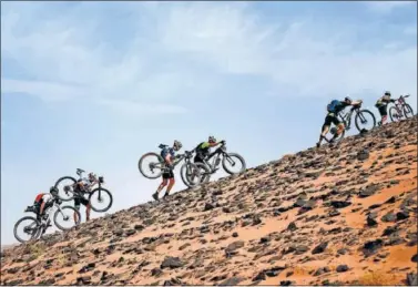  ??  ?? Seis participan­tes avanzan entre la arena y las rocas durante una etapa del pasado año en Marruecos.