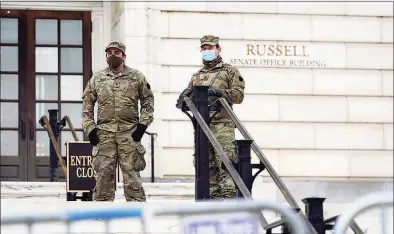  ?? Patrick Semansky / Associated Press ?? Members of the military stand guard outside Russell Senate Office Building on Capitol Hill in Washington on Friday in response to supporters of President Donald Trump who stormed the U. S. Capitol earlier in the week.