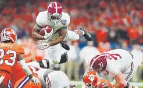  ?? Tom Pennington, Getty Images ?? Alabama running back Damien Harris soars for extra yardage Monday night in the Sugar Bowl as Clemson safety Van Smith defends.