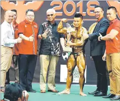  ??  ?? Joseph receives the Mr Kuching trophy from Abang Abdul Wahap.