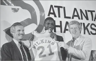  ?? ASSOCIATED PRESS FILE PHOTO ?? Dominique Wilkins, all time leading scorer at the University of Georgia, holds his Atlanta Hawks jersey flanked by coach Kevin Loughery, right, and owner Ted Turner on Sept. 4, 1982, in Atlanta.