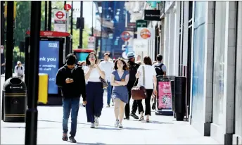  ??  ?? People walk past closed shops on Oxford Street in central London’s main high street retail shopping area ahead of some shops reopening from their Covid-19 shutdown from next week. — AFP photo
