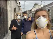  ??  ?? Jessica Coming, along with Eli Baginski and Michael Franklin, wear masks en route to a grocery store near their Airbnb in Arequipa.