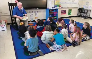  ?? Submitted photo ?? Blake Robertson, with the Greater Hot Springs Kiwanis Club, reads to students at Main Street Visual & Performing Arts Magnet School on Feb. 3 during the Trojans Love Reading event.