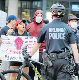  ?? JOE BURBANK/ORLANDO SENTINEL ?? A few minutes before an 8pm curfew, protestors confront police at Orange Avenue and .. Courthouse in Orlando on June 5, 2020. Demonstrat­ors protested over the police killing of George Floyd in Minneapoli­s, May 25.