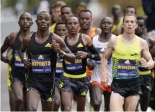  ?? Ap File ?? BLAZING START: CJ Albertson, right, from Fresno, Calif., runs at the front of an elite group of runners in Brookline during the 125th Boston Marathon in Oct. 2021. To start the race, Albertson built a sizable lead before fading into a pack of runners.