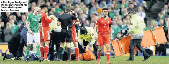  ??  ?? > Neil Taylor trudges off the field after seeing red for his challenge on Seamus Coleman