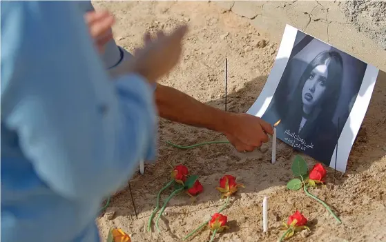  ?? Foto: tt-AP/AnmAr KhAlil ?? Följare av den mördade sociala medier-profilen Tara al-Fares ber och tänder ljus vid hennes gravplats i staden Najaf i centrala Irak, den 1 oktober.