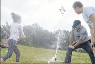  ?? JOE GIBBONS/THE TELEGRAM ?? One of the summer camp participan­ts launches their team’s bottle rocket with the assistance of former schoolteac­her John Barron, now program co-ordinator for Brilliant Labs, Wednesday on the large green-space embankment on the west end of the College of the North Atlantic campus on Prince Philip Drive.