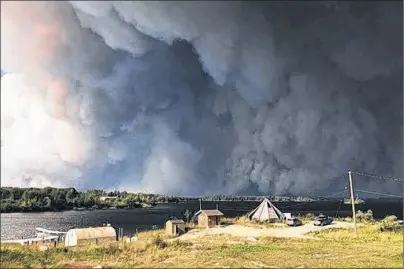  ?? CP PHOTO ?? Manitoba MLA Judy Klassen provided this image showing a large forest fire seen burning near Wasagamack First Nation in northern Manitoba on Tuesday. The Red Cross is working to carry out the evacuation of three northern Manitoba communitie­s threatened...