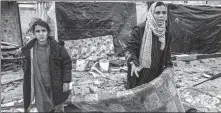  ?? SAID KHATIB / AFP ?? A woman holds a mattress while standing before shelters erected outside a damaged building at a Rafah refugee camp on Tuesday.