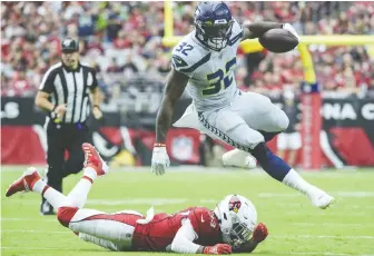  ?? JENNIFER STEWART/ GETTY IMAGES FILES ?? Chris Carson of the Seattle Seahawks gets past Byron Murphy of the Arizona Cardinals in a game last season. Arizona has allowed the second-fewest points in the NFL this season.
