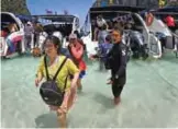  ??  ?? This photo shows tourists getting off a speedboat onto Maya Bay, on the southern Thai island of Koh Phi Phi.