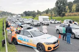  ?? /Freddy Mavunda ?? Johannesbu­rg metro police department officers at an M1 freeway roadblock on Sunday in Johannesbu­rg at which a number of motorists were arrested for travelling illegally during the Covid-19 lockdown. Johannesbu­rg mayor Geoff Makhubo joined the metro police officers conducting the roadblock.
Motorists arrested: