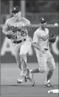  ?? AP/ALEX GALLARDO ?? Los Angeles Dodgers second baseman Chase Utley ( left) and his teammates can celebrate a National League Western Division title this week in Philadelph­ia, where Utley played for the Phillies from 2003-2014. Entering Monday night, the Dodgers magic...