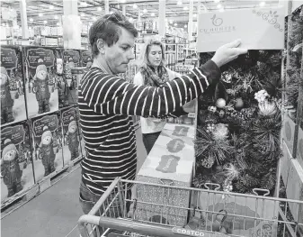  ?? Steve Gonzales / Staff photograph­er ?? Kati and Davis Rhett lost all their holiday decoration­s when their home was flooded. They took advantage of Black Friday to shop for new decoration­s at the Costco on Richmond.