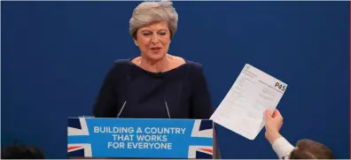  ?? Photo: Peter Byrne/PA ?? Comedian Simon Brodkin confronts British Prime Minister Theresa May with a P45 form during her keynote speech at the Conservati­ve Party conference in Manchester yesterday.