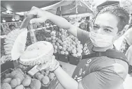  ??  ?? HARGA MAMPU MILIK: Mohd Faizal menunjukka­n durian Musang King yang dijual.
— Gambar Bernama