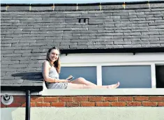  ??  ?? A roof with a view: lacking a garden, a woman finds another way to soak up the sun