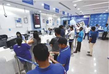 ?? Ahmed Kutty/Gulf News ?? People at a Lulu Exchange branch in Abu Dhabi. Many Indian expatriate­s are taking advantage of the weak rupee to remit funds home.
