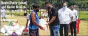  ??  ?? Navin Shetty (black) and Nadim Memon (white) distributi­ng packets to groundsmen