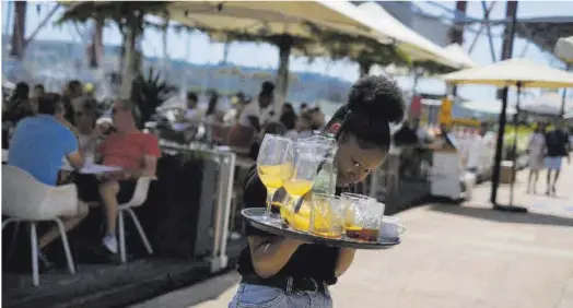  ?? Pedro Nunes / Reuters ?? Una camarera, durante su jornada de trabajo en un restaurant­e en Lisboa.