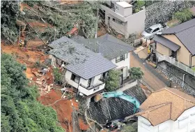  ??  ?? Rescuers search for survivors in Kitakyushu, Fukuoka, after torrential rain triggered landslides in western Japan.