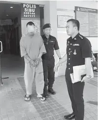  ??  ?? DIBERKAS: Suspek kes ragut dibawa keluar dari Balai Polis Sentral Sibu untuk proses permohonan tahanan reman di mahkamah.