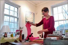  ?? TIM MARTIN/THE DAY ?? Kim Ford, co-owner of The Red House Cultural Arts Center in Salem, wraps up a hand-crafted wooden clock shaped like a heart, which also holds earrings, on Nov. 18. Barry Ford, co-owner and Kim Ford’s husband, made the clock.