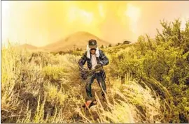  ?? Noah Berger Associated Press ?? DAVID GARFIELD clears a fire break around his home Saturday as the more than 54,000-acre Sugar fire, fueled by a heat wave, burns toward Doyle, Calif.