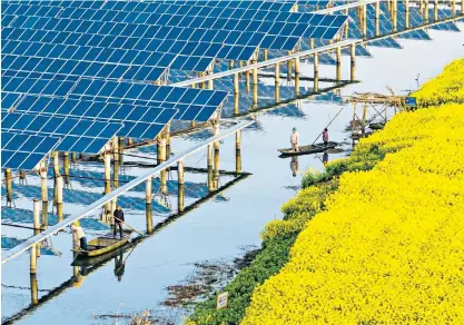  ?? ?? Power workers at the Taizhou ‘fishery-solar hybrid project’’ photovolta­ic plant in China’s Jiangsu province