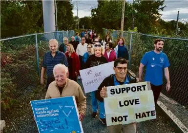  ?? CARLIN STIEHL FOR THE BOSTON GLOBE ?? Danvers community members marched against antisemiti­sm to reclaim the Rail Trail bridge over Route 114 that neo-Nazis tarnished on the 21st anniversar­y of the Sept. 11 terror attacks in Danvers on Sept. 28, 2022.