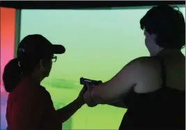  ??  ?? Yuma Police Department Lt. Claudia Leyva (left) instructs student Rysalynn Richey inside the VirTra simulator.