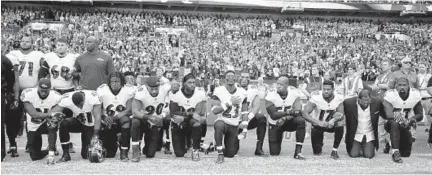  ?? MATT DUNHAM/ASSOCIATED PRESS ?? Ravens players, including former player Ray Lewis, second from right, kneel down during the playing of the national anthem last week.