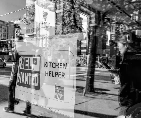  ?? REUTERS ?? A help wanted sign hangs in a bar window along Queen Street West in Toronto, June 10.