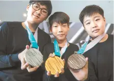  ?? Yonhap ?? Young athletes display the 2018 PyeongChan­g Winter Olympic medals at Dongdaemun Design Plaza in Seoul, Thursday.