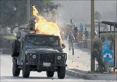  ?? ABBAS MOMANI / AFP ?? Un vehículo militar israelí es atacado con cócteles molotov en un asentamien­to judío cerca de Ramala