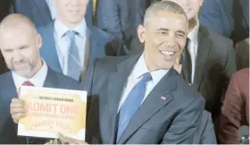  ??  ?? El presidente Barack Obama muestra un pase de acceso vitalicio al Wrigley Field, hogar de los Cachorros de Chicago.