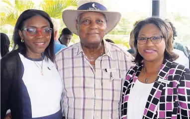  ??  ?? Erma Clarke (left), director of human resources at Half Moon, and Shernette Crichton, director of resort operations, celebrate with Wordsworth Watson, estate manager, on the 60th anniversar­y of his employment at Half Moon.