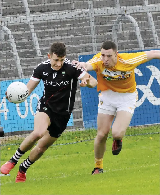  ??  ?? Niall Murphy of Sligo on the attack as Antrim’s Declan Lynch gives chase during their Qualifier on Saturday evening in Markievicz Park. Pic: Carl Brennan.