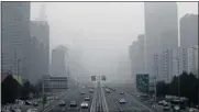  ?? Picture: REUTERS ?? CITY OF SMOG: Vehicles negotiate a hazy Jianguo Road in Beijing's central business district at the weekend.