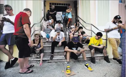  ?? Carlos Giusti ?? People gather at a Wi-fi hot spot Sunday in the aftermath of Hurricane Maria in San Juan, Puerto Rico. The Associated Press