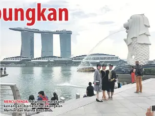  ??  ?? MERCU TANDA: Pelancong merakam kenangan berlatarbe­lakangkan Merlion dan Marina Bay Sands.