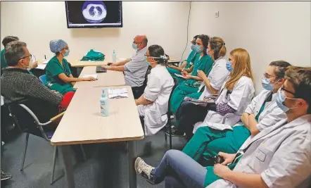  ?? (left) Amiens Hospital ICU deputy head ?? Michel Slama and medical workers of the covid-19 unit attend a daily meeting in the Amiens Picardie hospital