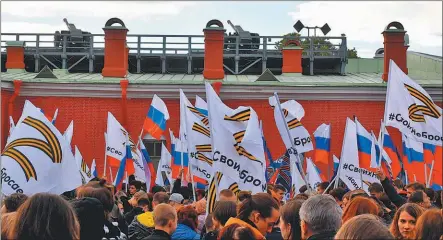  ?? FOTOS: AFP ?? VOTO. Un miliciano prorruso en una de las “repúblicas” del este ucraniano ocupadas por Rusia. En San Petersburg­o, una multitud festejó el inicio de la consulta.