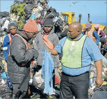  ?? Picture: EUGENE COETZEE ?? DANGEROUS JOB: Mveleli Maneli, who picks through refuse at the Arlington tip to make a living, speaks to deputy mayor Mongameli Bobani