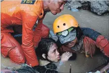  ?? ARIMACS WILANDER THE ASSOCIATED PRESS ?? A woman is rescued Sunday from a damaged house after an earthquake and a tsunami in Palu, Indonesia. .