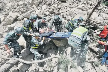  ??  ?? Chinese paramilita­ry police carry a survivor after an earthquake in Jiuzhaigou county, Ngawa prefecture, Sichuan province, China. — Reuters photo