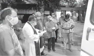  ?? CEDRIC PRAKASH ?? Priests pray over the body of the Rev. Jerry Sequeira in April before his cremation in Ahmedabad, India. Sequeira is one of more than 500 Catholic priests and nuns who have died from COVID-19 since mid-April in India.